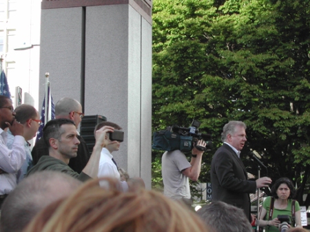 Senator Ed Murray preparing to speak; Columnist Dan Savage in foreground
